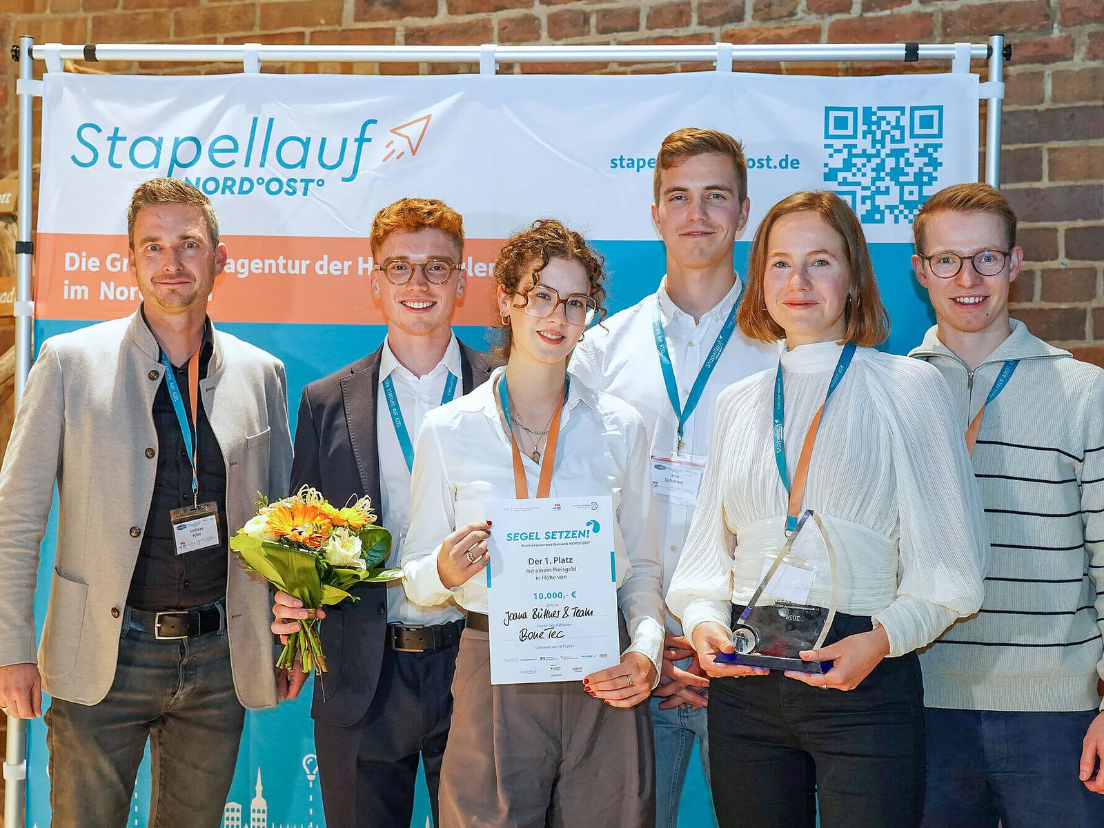 Preisträgerteam BoneTech des Businessplanwettbewerb MV 2024 mit der Urkunde für den 1. Platz (10.000 €) und Glaspokal.